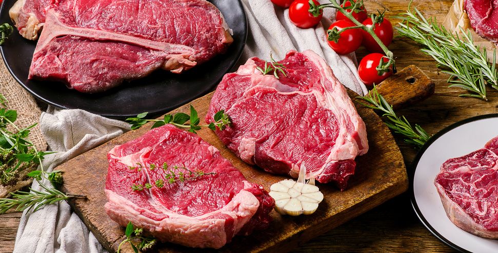 Raw beef cuts on a wooden board